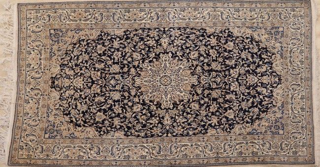 TAPIS en laine à riche décor de rinceaux...