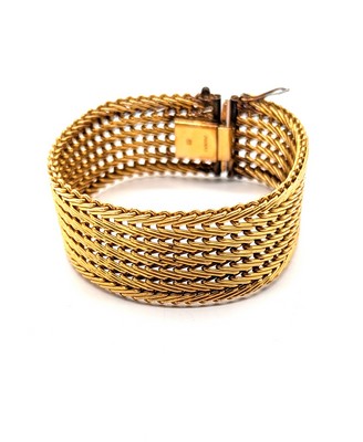 BRACELET MANCHETTE souple en métal doré.