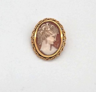 BROCHE en métal doré enserrant un camée sur...